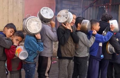 bambini palestinesi in coda per ricevere cibo